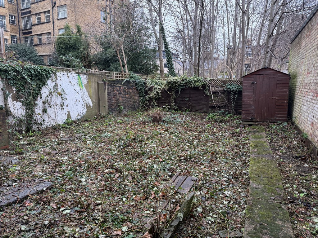 Lot: 19 - LAND WITH POTENTIAL JUST OFF CLAPHAM COMMON - Land showing walled area and shed